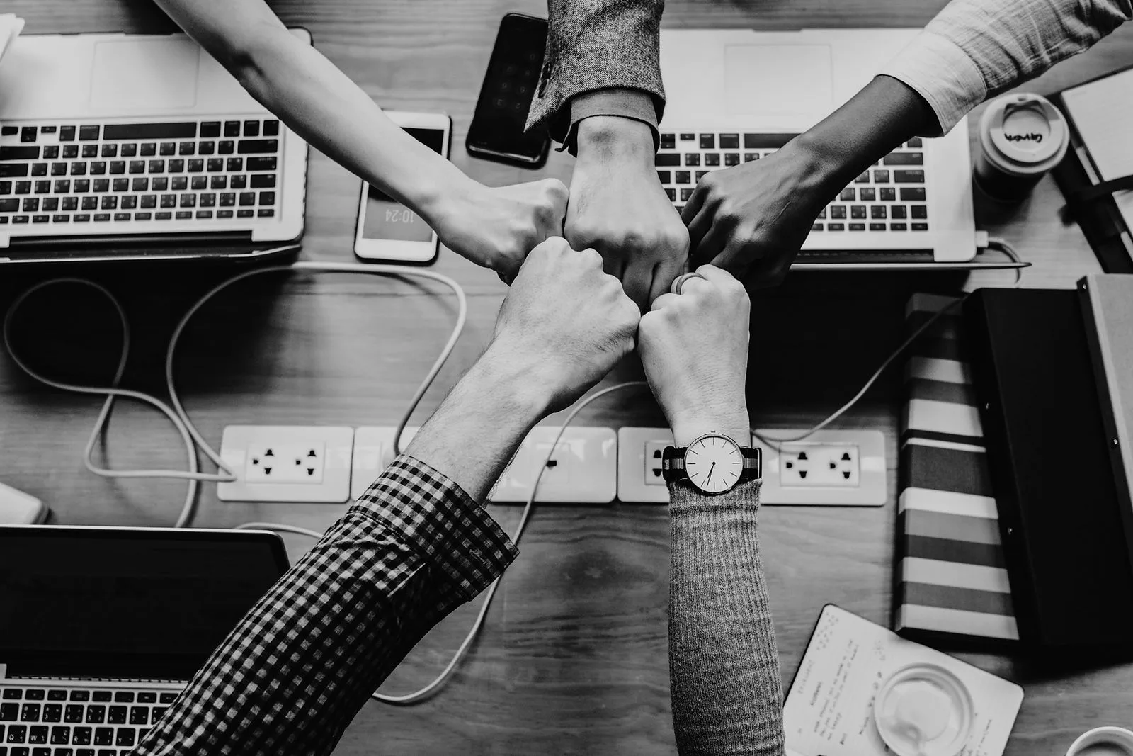 Team fist bump over laptops