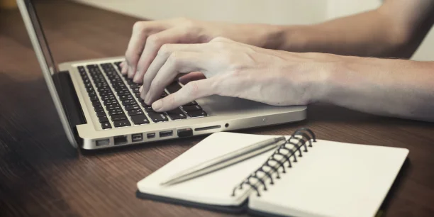 Person typing the form on a laptop